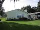 Light green single story home with large windows and a golf cart at 10742 W Beach Pkwy, Lake Wales, FL 33898