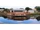 Home with large deck and waterfront access, reflecting in the water at 535 Minnow Ct, Kenansville, FL 34739