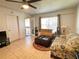 Living room with tiled floor, floral sofa, and access to a balcony at 8206 Fairways Cir # B204, Ocala, FL 34472