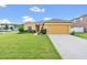 House exterior featuring a two-car garage and well-maintained lawn at 1801 Stargazer Trl, Kissimmee, FL 34758