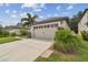 Two-car garage with light beige doors and landscaped front yard at 6294 Manitoba Dr, Lakeland, FL 33805