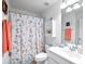 Clean bathroom with floral shower curtain, white vanity, and coral towels at 8311 Foster Dr, Davenport, FL 33896
