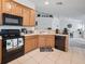 Modern kitchen with stainless steel appliances and light wood cabinets at 8311 Foster Dr, Davenport, FL 33896