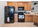 Kitchen features black appliances and light wood cabinets at 8311 Foster Dr, Davenport, FL 33896
