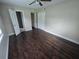 Bedroom with dark hardwood floors, ceiling fan, and access to bathroom at 2501 Gulfstream Rd, Orlando, FL 32805