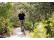 Personal riding a bike on a wooded nature trail at 3068 Bootlace Way, Saint Cloud, FL 34771