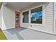 Covered patio with orange door and view of homes at 3062 Bootlace Way, Saint Cloud, FL 34771