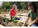 Two women tending plants in a community garden at 3062 Bootlace Way, St Cloud, FL 34771