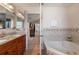 Bathroom with soaking tub, double vanity, and granite countertop at 105 Hainesport Dr, Lake Alfred, FL 33850