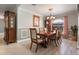 Elegant dining room with a large wooden table, chandelier, and hardwood floors at 105 Hainesport Dr, Lake Alfred, FL 33850