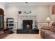 Cozy living room featuring a fireplace and built-in shelving at 105 Hainesport Dr, Lake Alfred, FL 33850