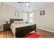 Well-lit bedroom with a floral comforter and hardwood floors at 6505 Raintree Ne Ln, Winter Haven, FL 33881