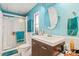 Charming bathroom with teal walls, walk-in shower, and modern vanity at 6505 Raintree Ne Ln, Winter Haven, FL 33881