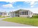 Exterior view of a manufactured home with a covered carport and landscaped lawn at 6505 Raintree Ne Ln, Winter Haven, FL 33881