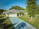 Single-story house with driveway, garage, and large front yard at 6556 Red Grange Blvd, Indian Lake Estates, FL 33855