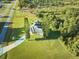 House with driveway and large backyard, surrounded by trees at 6556 Red Grange Blvd, Indian Lake Estates, FL 33855