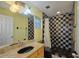 Bathroom with granite vanity, checkered shower, and grab bars at 6556 Red Grange Blvd, Indian Lake Estates, FL 33855