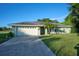 Front view of a single-story house with a driveway and landscaped yard at 6556 Red Grange Blvd, Indian Lake Estates, FL 33855