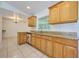Kitchen with wood cabinets, granite countertops, and tile floors at 6556 Red Grange Blvd, Indian Lake Estates, FL 33855