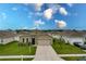 Tan house with a two-car garage and well-maintained lawn at 6048 Forest Ridge Ln, Winter Haven, FL 33881