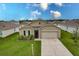 Tan house with a two-car garage and manicured lawn at 6048 Forest Ridge Ln, Winter Haven, FL 33881