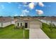 Tan house with a two-car garage and landscaped front yard at 6048 Forest Ridge Ln, Winter Haven, FL 33881