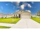 Tan one-story house with a two-car garage and landscaped yard at 6048 Forest Ridge Ln, Winter Haven, FL 33881