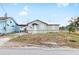 Tan house with a metal roof, front yard, and chain link fence at 102 Se 6Th Ave, Mulberry, FL 33860