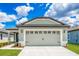 Newly constructed home with a two-car garage, attractive exterior, and a well-maintained lawn at 3816 Corsican Pl, Lake Alfred, FL 33850