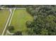 Aerial view of vacant land with road access and lush green surroundings at 1440 Duff Rd, Lakeland, FL 33810