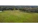 Aerial view of expansive pasture land with mature trees and a pond at 1440 Duff Rd, Lakeland, FL 33810