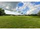 Cattle grazing in a lush green pasture with distant barns at 1440 Duff Rd, Lakeland, FL 33810