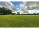 Spacious green pasture with mature trees and distant buildings at 1440 Duff Rd, Lakeland, FL 33810