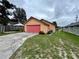 Single car garage with red door and paved driveway at 819 Ariana St, Lakeland, FL 33803