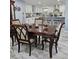 Dining area with wooden table, view of the kitchen, and marble-look tile flooring at 4810 N Galloway Rd, Lakeland, FL 33810