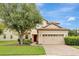 Two-story house with tan exterior, tile roof and three-car garage at 9151 Wedge Dr, Davenport, FL 33896