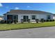 Rear view of a house with a screened porch and landscaping at 4415 Casey Ct, The Villages, FL 32163