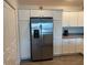 Stainless steel refrigerator with ample storage in white cabinets at 4415 Casey Ct, The Villages, FL 32163