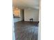 Open living room with gray vinyl flooring and kitchen view at 4415 Casey Ct, The Villages, FL 32163