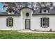 Modern home exterior with gray door and black shutters at 225 Diesel Rd, Mulberry, FL 33860