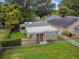 Aerial view of a tan house with red door, small yard, and surrounding trees at 5210 Vatican Ave, Orlando, FL 32810