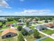 Aerial view of a residential neighborhood with houses, yards and a lake at 5411 Great Egret Dr, Leesburg, FL 34748