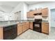 Modern kitchen with wood cabinets, black appliances, and granite countertops at 5411 Great Egret Dr, Leesburg, FL 34748