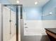 Bathroom with shower and tub, white tiled walls, and a light blue color scheme at 5411 Great Egret Dr, Leesburg, FL 34748