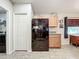 Kitchen with black refrigerator and ample wood cabinets at 5411 Great Egret Dr, Leesburg, FL 34748
