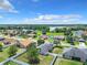 Aerial view of a residential neighborhood with houses, yards, and a lake in the background at 5411 Great Egret Dr, Leesburg, FL 34748
