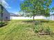 Backyard with a large tree, garden and white vinyl fence at 5411 Great Egret Dr, Leesburg, FL 34748