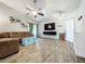 Bright living room featuring a brown sectional sofa, tile floors, and a large flat-screen TV at 5411 Great Egret Dr, Leesburg, FL 34748