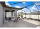 Spacious screened lanai with lounge chairs and dining table at 251 Tomelloso Way, Davenport, FL 33837