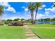 Stone path meandering through a grassy area towards a lake at 251 Tomelloso Way, Davenport, FL 33837